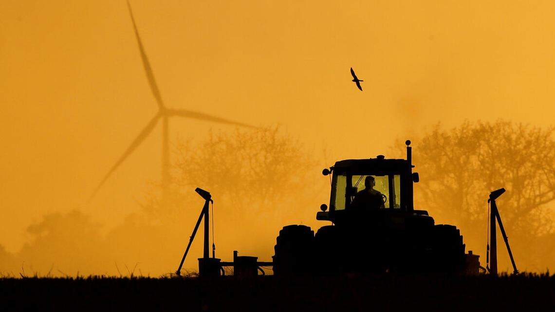 Dallas Koehn plants milo in his field as wind turbines rise in the distance, near Cimarron, Kan. President Donald Trump announced the Coronavirus Food Assistance Program to help farmers, ranchers and others in the food industry impacted by the coronavirus pandemic with $16 billion is going directly to farmers and ranchers. (AP Photo/Charlie Riedel/Tuesday, May 19, 2020)