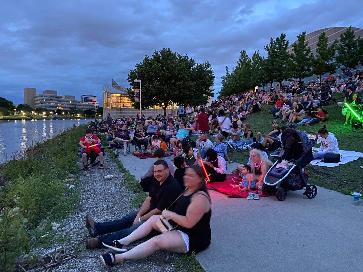 People gathered on the riverbank outside Exploration Place on Sunday to watch the city’s first drone show.