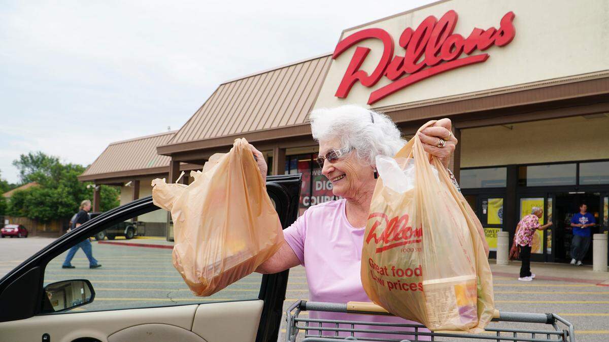 LaDora Bishop loads groceries into her car at the Dillons at Douglas and Hillside. Dillons parent company Kroger Co. plans to phase out the use of single-use plastic bags by 2025. (August 23, 2018)