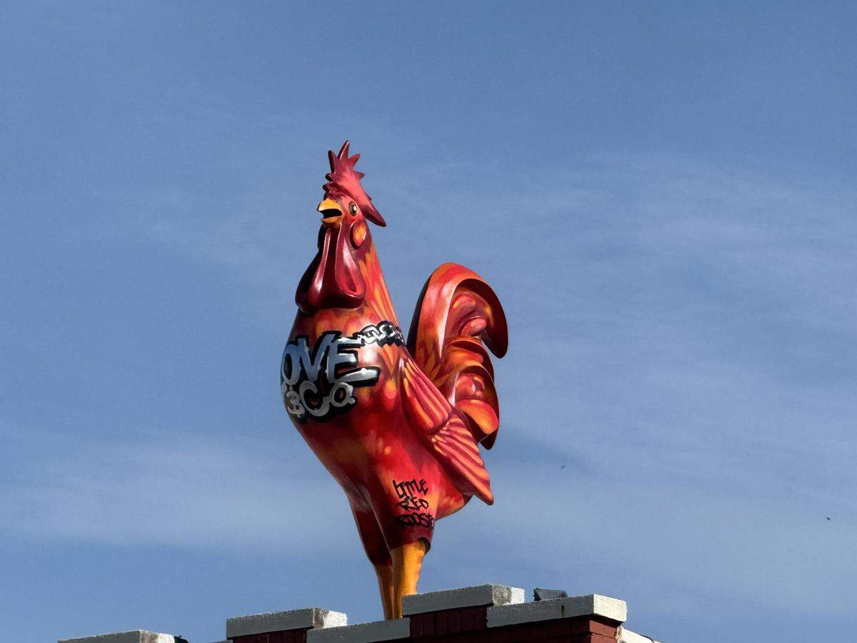 The new Love & Co. Kitchen & Cocktails now has a flaming red rooster named Little Red atop its building.