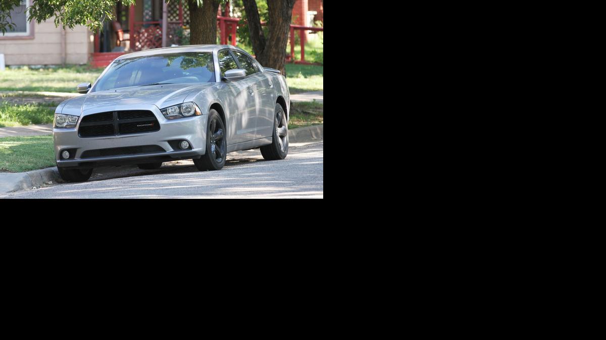 A gray Dodge Charger sits in front of a house in the 1500 block of South Topeka Friday morning. A child died after being left in the vehicle.

