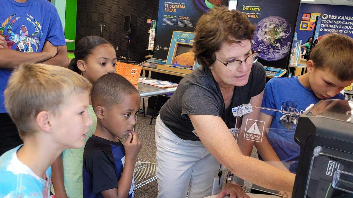 Lynn Woolf, director of education, shows a group of students how to use the 3D printer at the PBS Kansas Cochener-Garvey Children’s Education & Development Center.