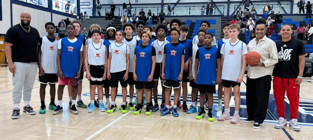 Boys basketball players pose for a picture after playing in a middle school all-star game.