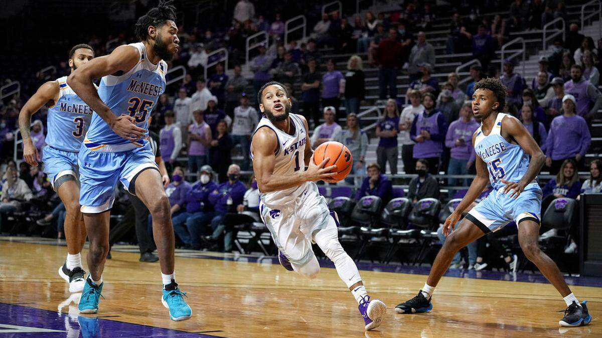 Kansas State’s Markquis Nowell (1) drives between McNeese State’s Brendan Medley-Bacon (35) and Zach Scott (15) during the first half of an NCAA college basketball game Tuesday, Dec. 21, 2021, in Manhattan, Kan. (AP Photo/Charlie Riedel)