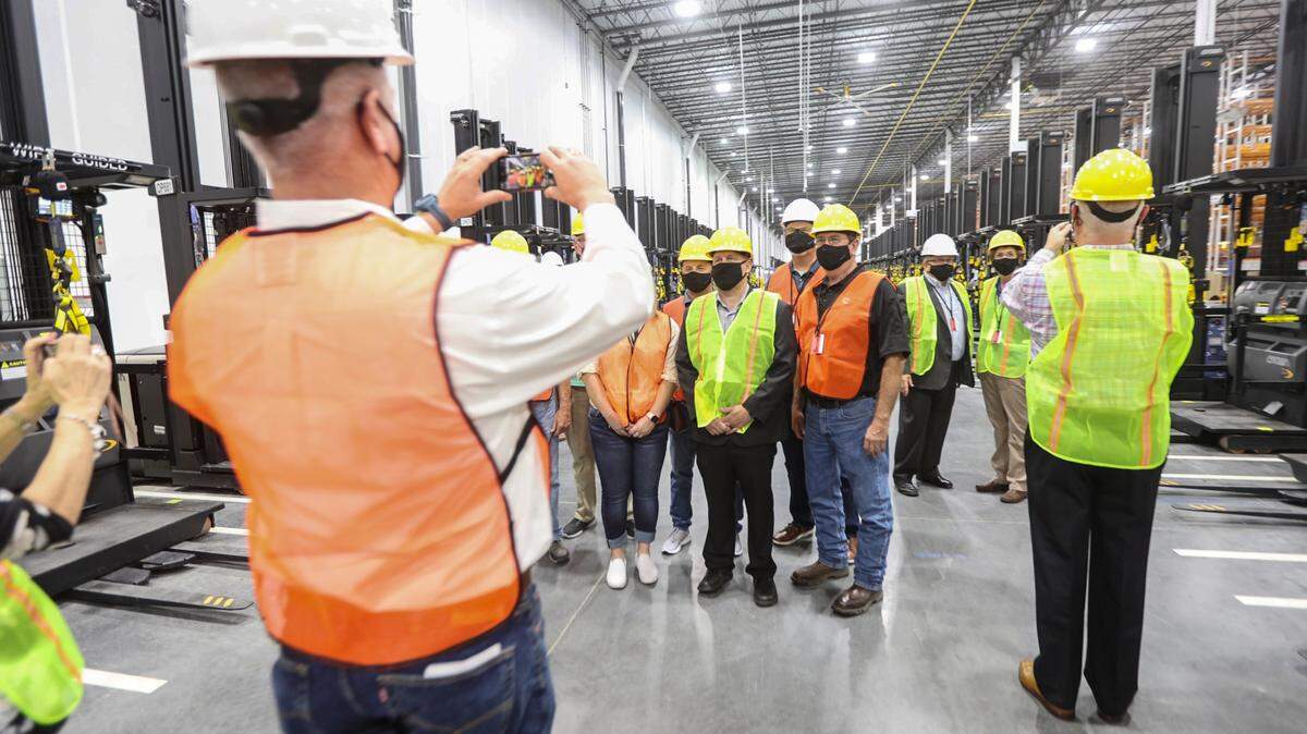 Local, state and federal dignitaries take photos inside the new Amazon distribution center in Park City on Friday.