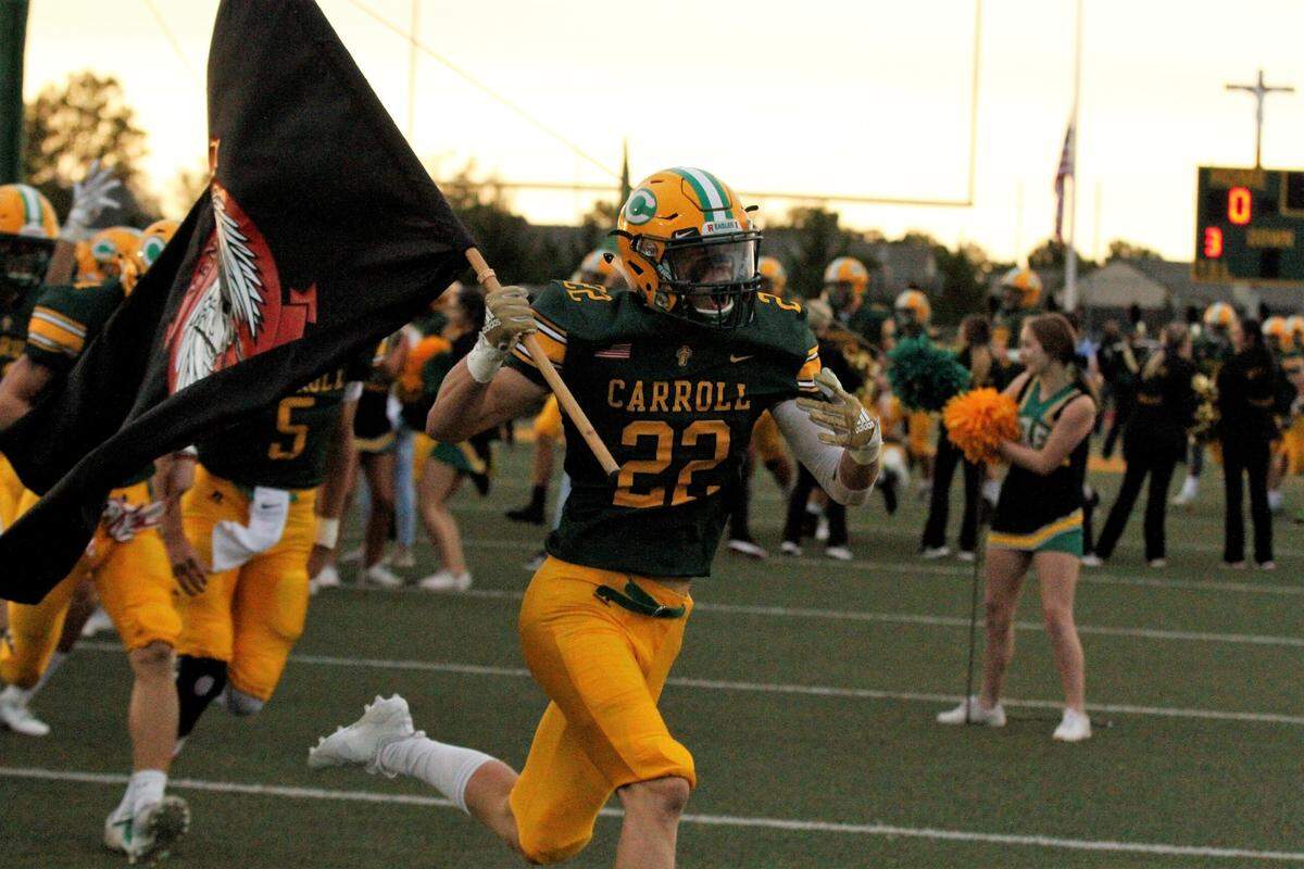 Bishop Carroll senior receiver Gunner Lynch leads the Golden Eagles onto the field for their game against Derby on Friday. (Sept. 21, 2018)