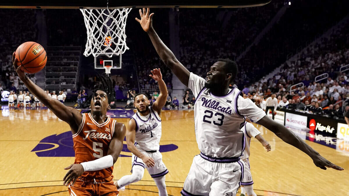 Texas guard Marcus Carr gets by Kansas State center Abayomi Iyiola and the rest of the Wildcats defense on Saturday, Feb. 4, 2023, in Manhattan, Kan.