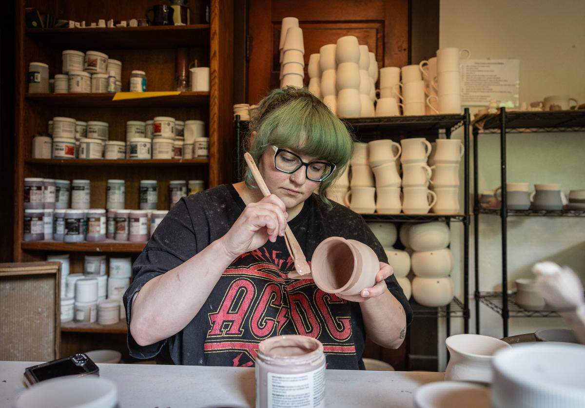 Hannah Chester glazes pottery at LegacyWorks on South Water Street on Wednesday. AmeriCorps members working at LegacyWorks were paid through the federal program, which had its Kansas funding eliminated.