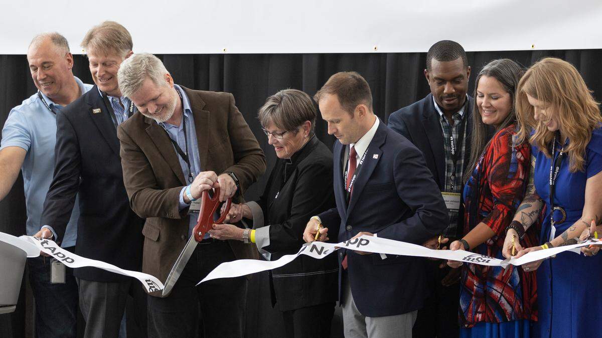 NetApp executives, Wichita State leaders, local dignitaries and Kansas Gov. Laura Kelly, middle, cut a ceremonial ribbon on Wednesday to officially open the new NetApp building on Wichita State’s Innovation Campus.