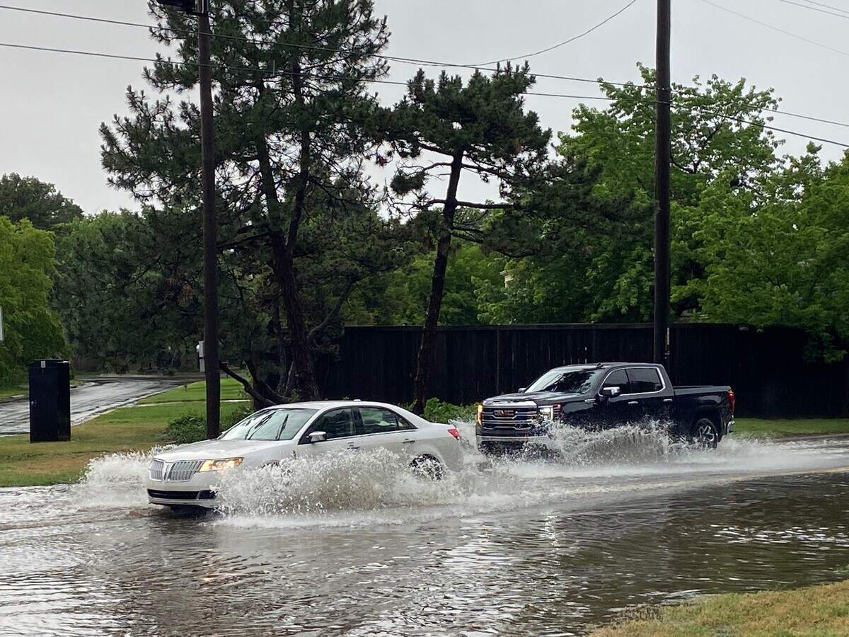 Cars proceed through water at Douglas and Woodlawn in east Wichita on Tuesday afternoon. The National Weather Service issued a flash flood warning for Wichita east of I-135.