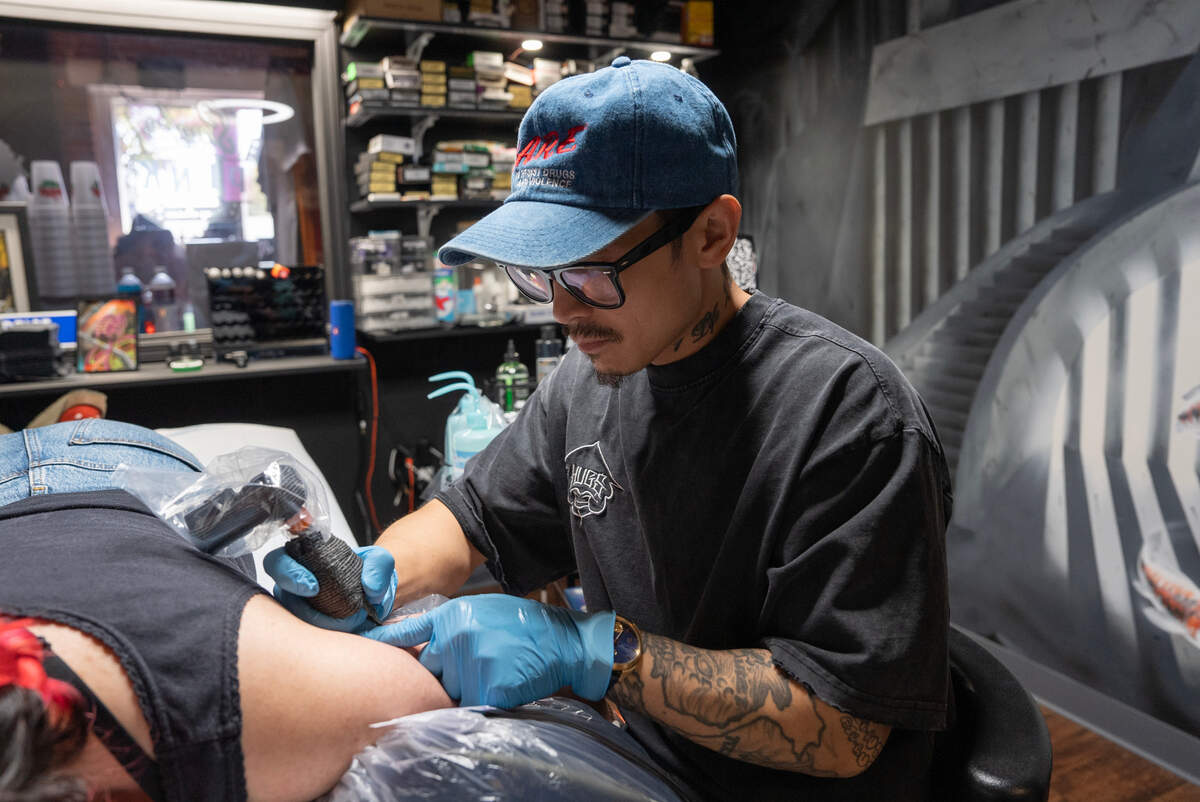 Tattoo artist Thanh Do works on a client, Allison Song, at his Afterlife Tattooz in Old Town. Following his opening last year, Do learned that tattoo parlors are not allowed there, but city code potentially could change in his favor.