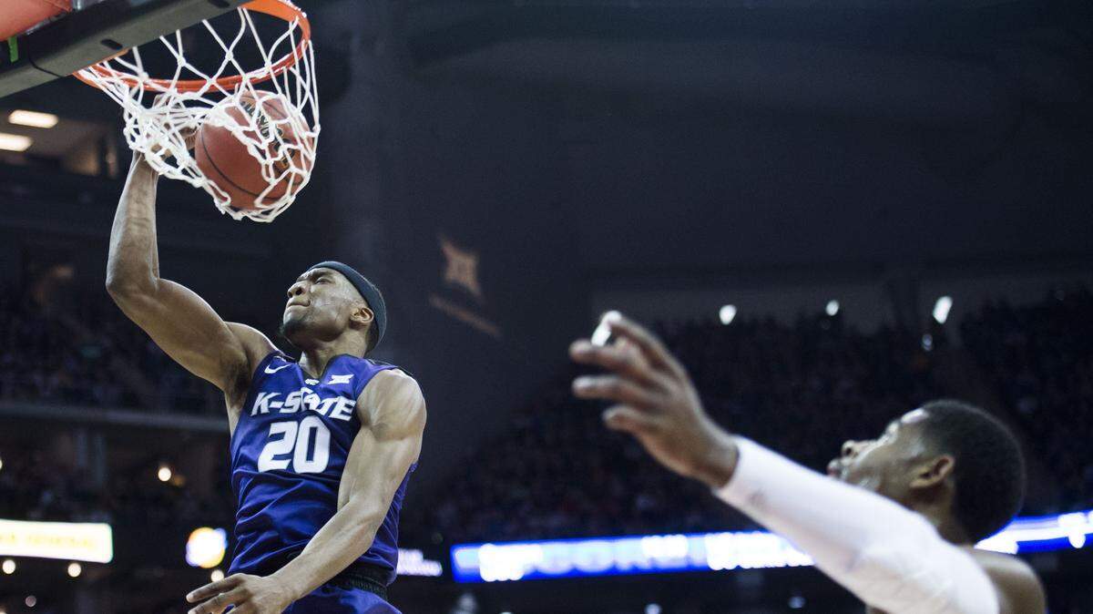 Kansas State Wildcats forward Xavier Sneed (20) dunked as Kansas Jayhawks guard Malik Newman (14) watched in the first half of the Kansas State Univeristy and University of Kansas semifinal round of the Big 12 Tournament at the Sprint Center on Friday, March 9, 2018, in Kansas City, Missouri.