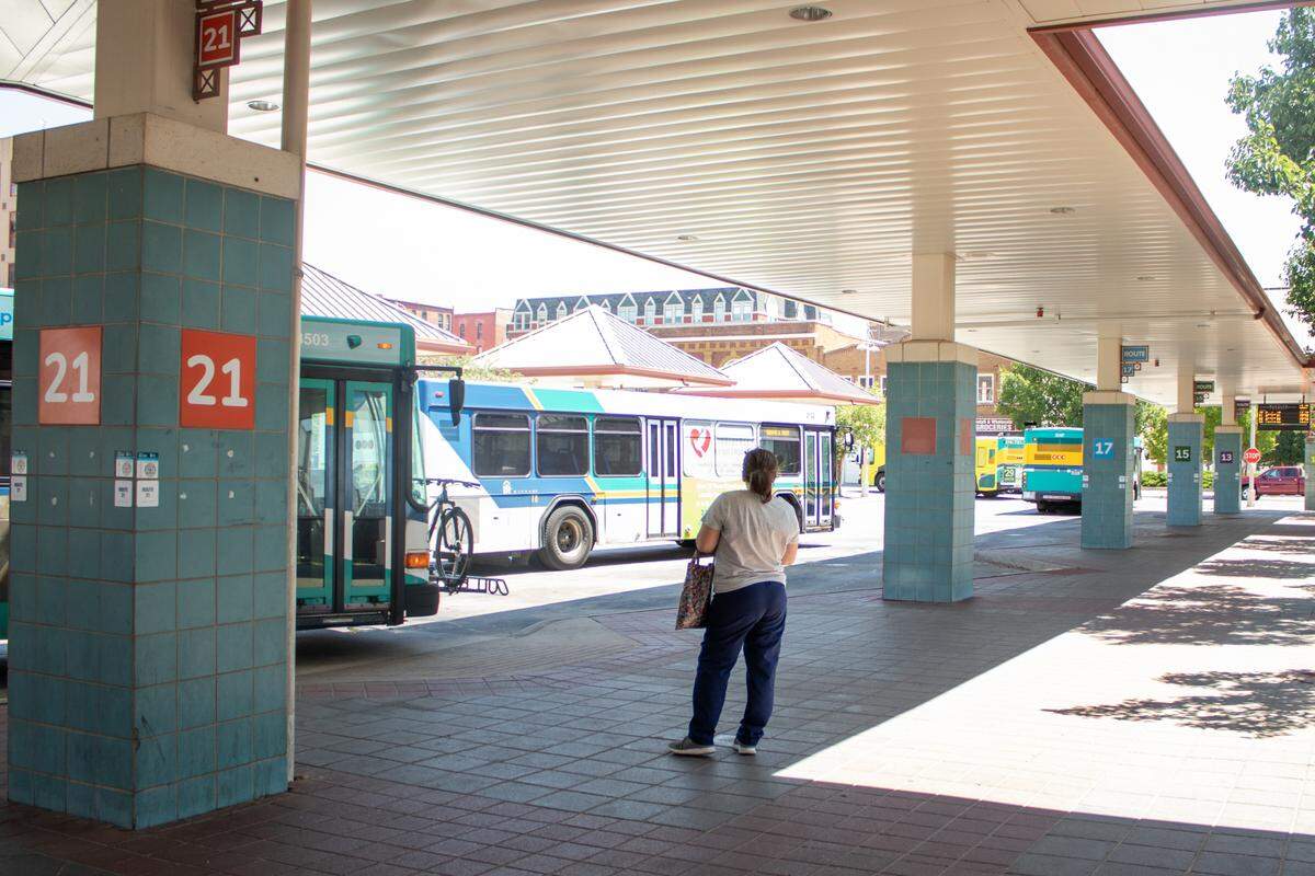 A rider waits for the buses to come into the Transit Center on July 11. Wichita’s buses typically run every 45 minutes to an hour, making riders wait often.