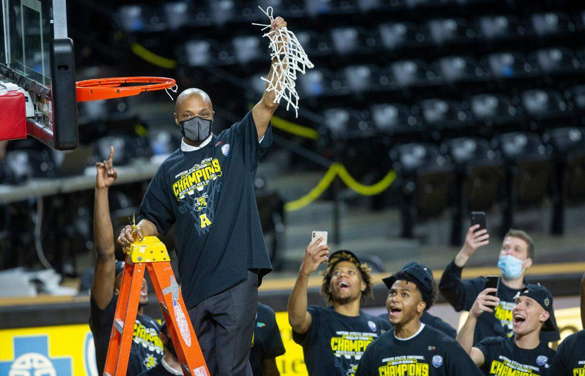 Wichita State head coach Isaac Brown cuts down the net after the Shockers clinched the American Athletic Conference title on Saturday. Brown spent most of the season as the interim head coach after the abrupt resignation of longtime head coach Gregg Marshall. Wichita State was predicted to finish seventh in the conference.