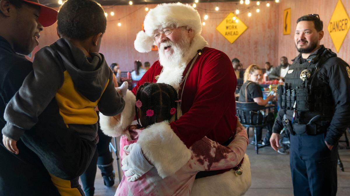 Santa greets guests to the Wichita Police Department’s Holiday Feast held at Pig In Pig Out BBQ on Sunday. Wichita police officers invited people they thought could benefit from the free meal provided by the restaurant and gifts provided by the officers and the community. This is the thirteenth year the department has held this event under the direction of Sgt. Ken Kimble.