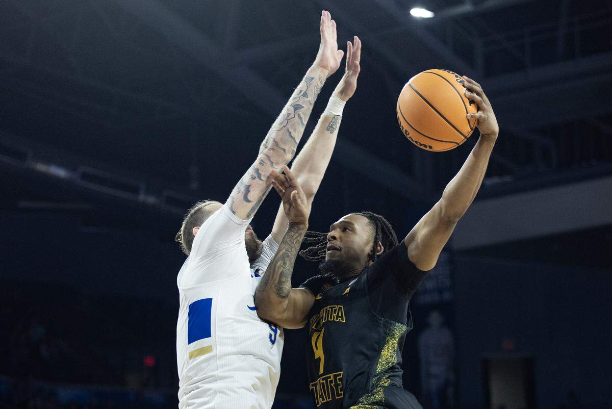 Wichita State TJ Williams shoots around Tulsa’s Tyler Behrend during the second half of their NIT quarterfinal game on Tuesday.