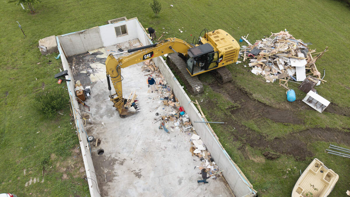 Debris is cleared from a home that an EF-2 tornado hit in northern Sedgwick County over the weekend.
