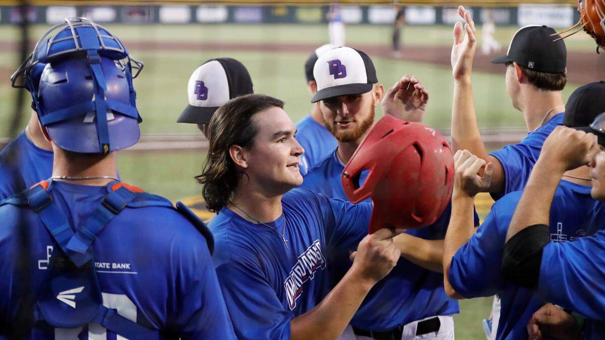 Tresten Kennard celebrates with teammates after scoring a run in the Cheney Diamond Dawgs’ 13-3 victory over the Kansas Cannons in Friday’s National Baseball Congress World Series semifinals at Eck Stadium.