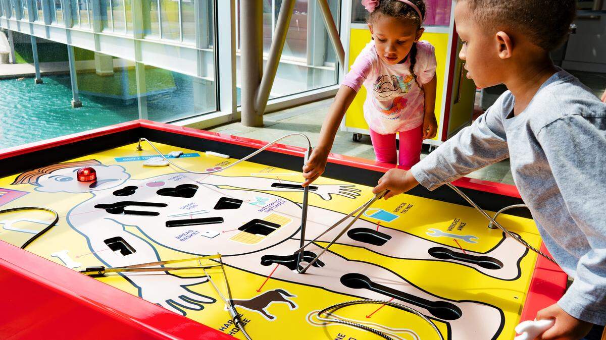 Health Inside Out, Exploration Place’s new permanent display, lets visitors try their skilled hands at an oversized Operation game.