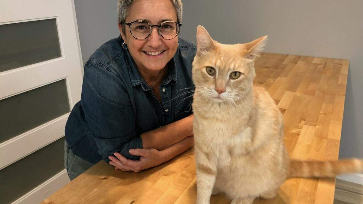 Lisa Grivois, shown with her cat, Nibbly, is opening Feline Groovy to sell fun and functional items for cats and their owners, who may not have as many retail options as dogs and their owners.