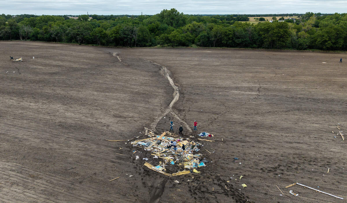Friends and family members look for items to salvage after a EF-2 tornado killed Ricky Schale in northern Sedgwick County over the weekend. The debris shown here was blown to the north at least 500 feet from the mobile home the tornado hit.