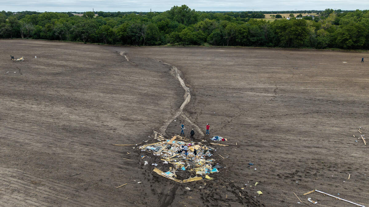 Friends and family members look for items to salvage after a EF-2 tornado killed their loved one in northern Sedgwick County over the weekend. The debris shown here was blown to the north at least 500 feet from the mobile home the tornado hit.