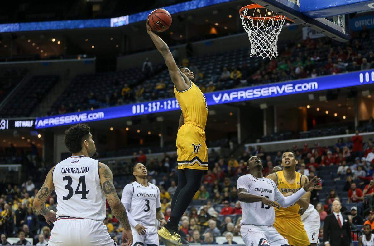 Wichita State guard Jamarius Burton dunks over Cincinnati forward Tre Scott during the first half of their American Athletic Conference semifinal game in Memphis on Saturday.