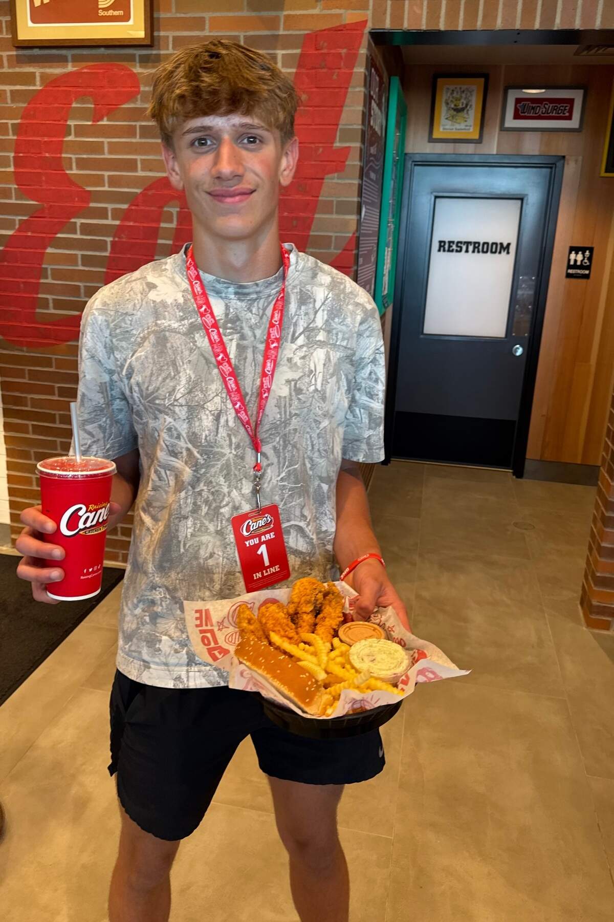 Elliott Hochstetler is pictured on Tuesday morning in Wichita’s new Raising Cane’s chicken finger restaurant. He camped out overnight to become the restaurant’s very first official customer.