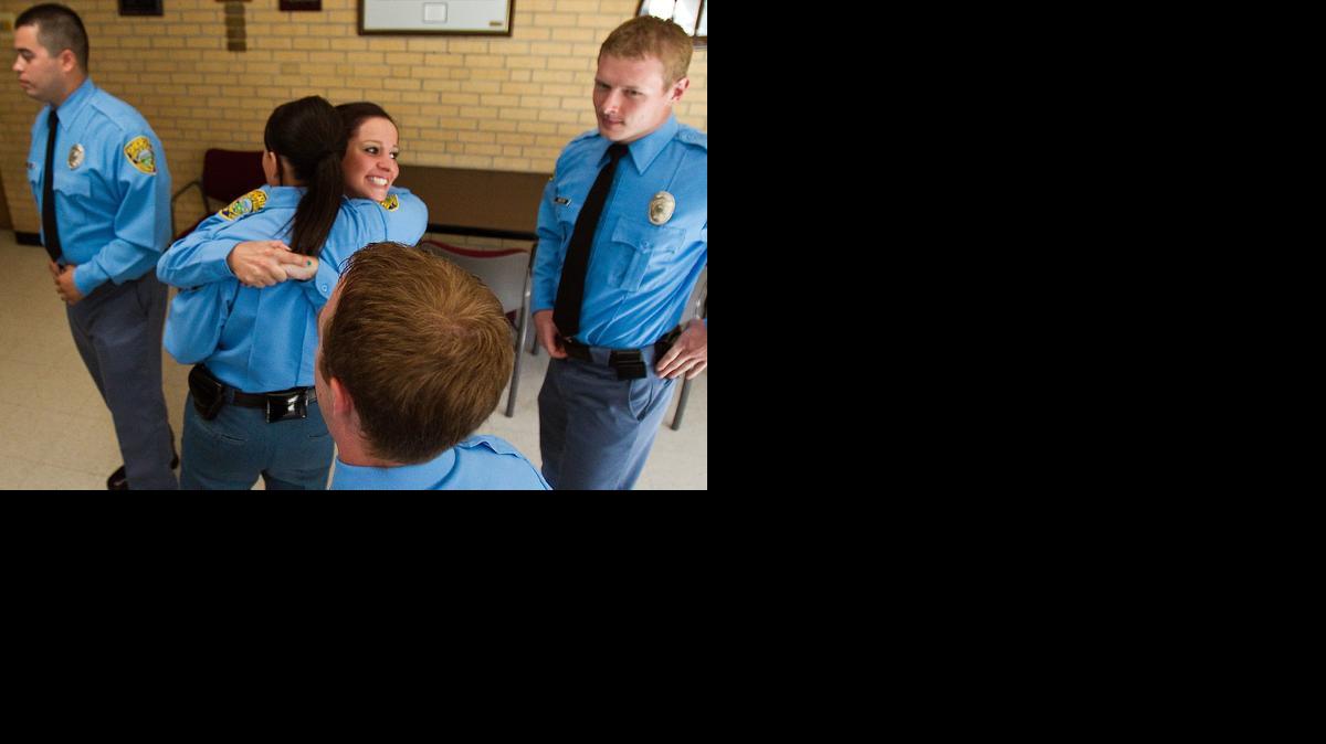 Deputies hug following a graduation ceremony. Seventeen new sheriff’s deputies completed their training to be detention deputies at the Sedgwick County Jail. (June 22, 2012)

