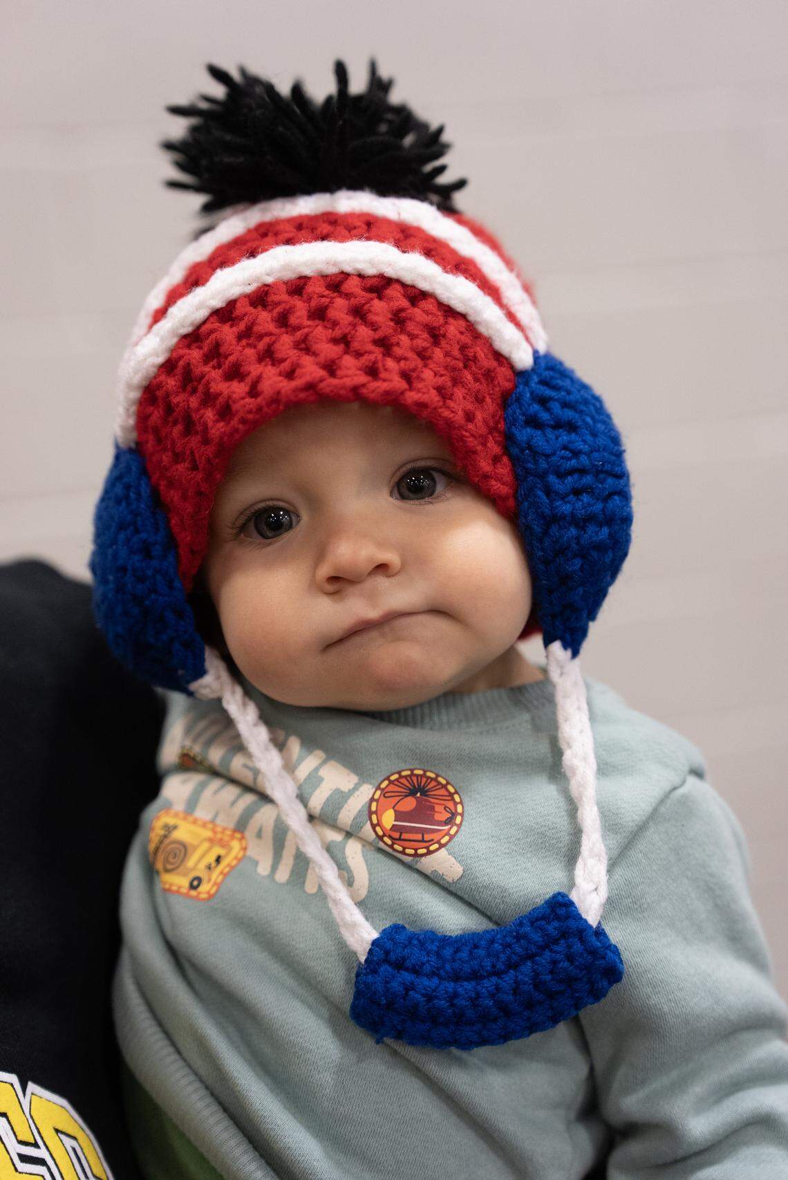 Southeast’s head coach Karson Arehart’s child Enzo wears a hat that his dad wore as a wrestler for South High. Enzo and his family were at the KSHSAA 6A West Regional wrestling tournament at North High School.