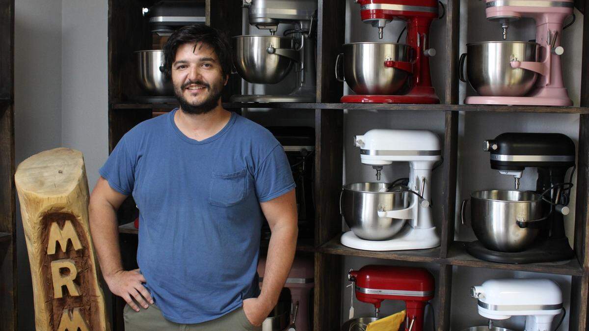 Zach Dinicola operates Mr. Mixer, a five-person KitchenAid mixer repair business, out of Augusta. Here he stands in the entrance to his repair shop. The mixers behind him are all used and repaired.