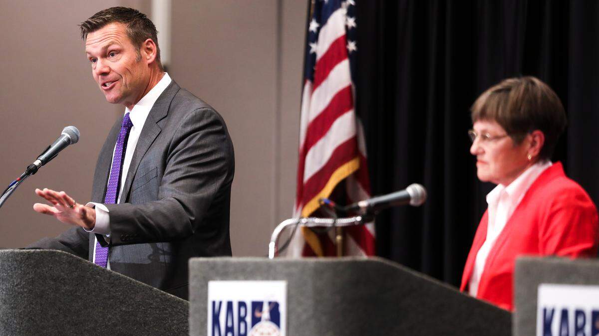 Republican Secretary of State Kris Kobach answers a question as Laura Kelly looks on during the Kansas Gubernatorial Debate at the Luncheon for the Kansas Association of Broadcasters, on Tuesday, in Wichita. (Oct. 16, 2018)