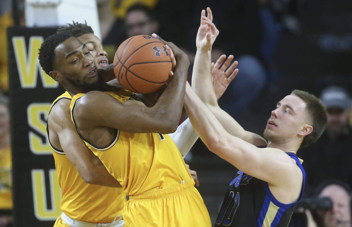 Wichita State forward Markis McDuffie fights for rebound against Tulsa guard Curran Scott during the first half of their game at Koch Arena on Saturday.