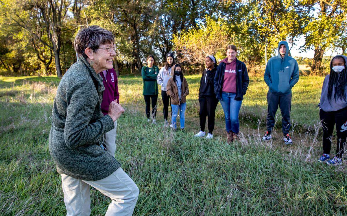 Lorna Harder, left, a professor emeritus of environmental biology, talks to a class from Hesston College about the prairie and her efforts to restore it to its natural state on her property in Hesston, Kansas.