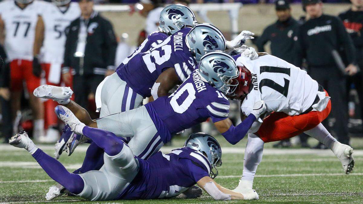 Cincinnati Bearcats running back Corey Kiner (21) is tackled by several Kansas State Wildcats defenders during the third quarter at Bill Snyder Family Football Stadium.