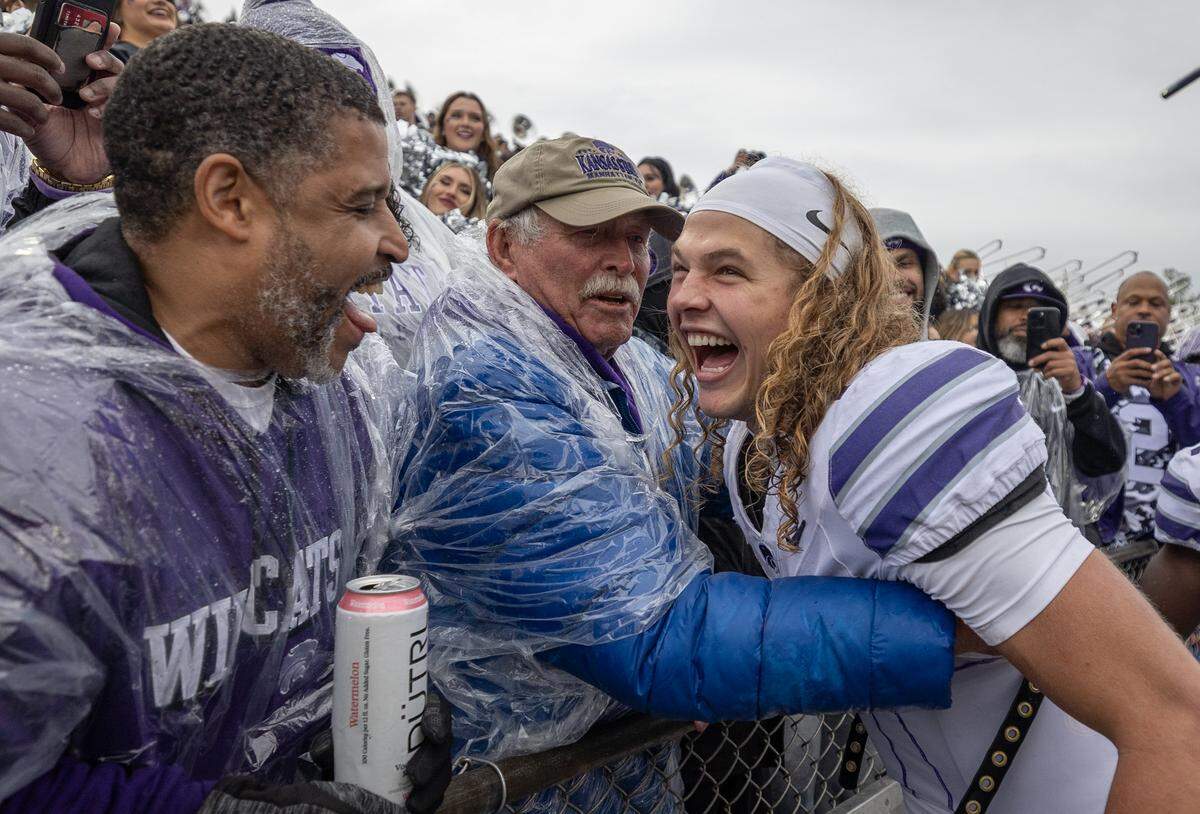 Kansas State quarterback Avery Johnson celebrates with fans after the Wildcats won their 17th straight game against Kansas at David Booth Kansas Memorial Stadium on Saturday.