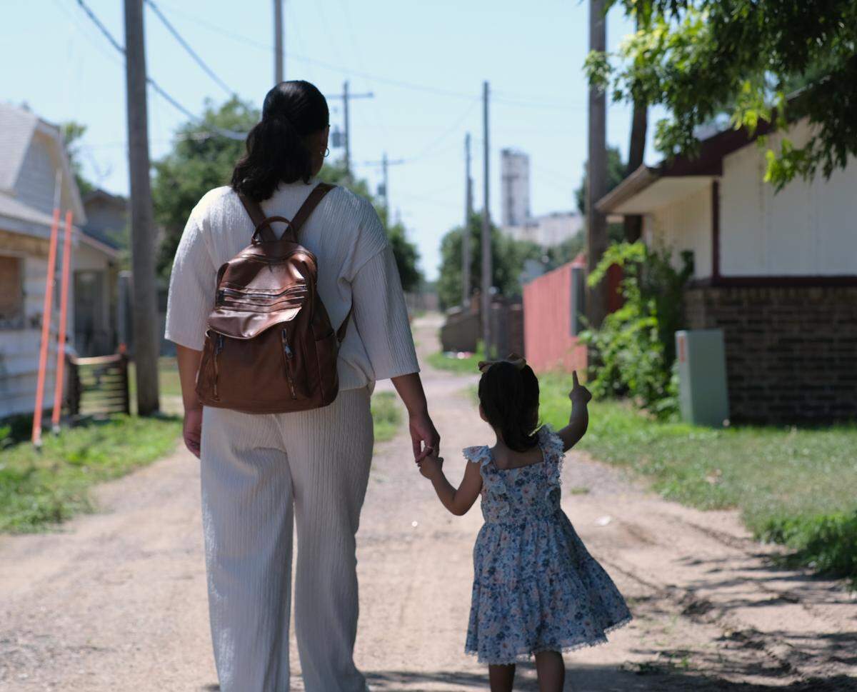 Isabel Yara holds her daughter’s hand as the two make their way to the car before driving their usual hour-long trip for a doctor’s appointment.