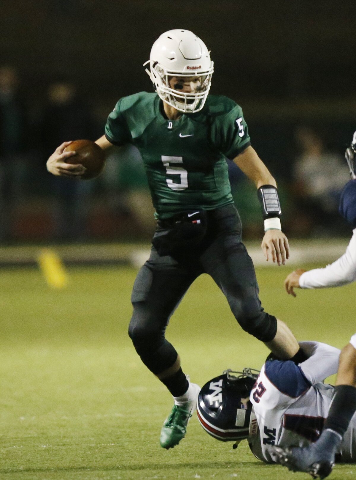 Manhattan defender #24 Reshon Moore grabs Derby quarterback Hunter Igo by the leg Friday night.  (November 16, 2018)