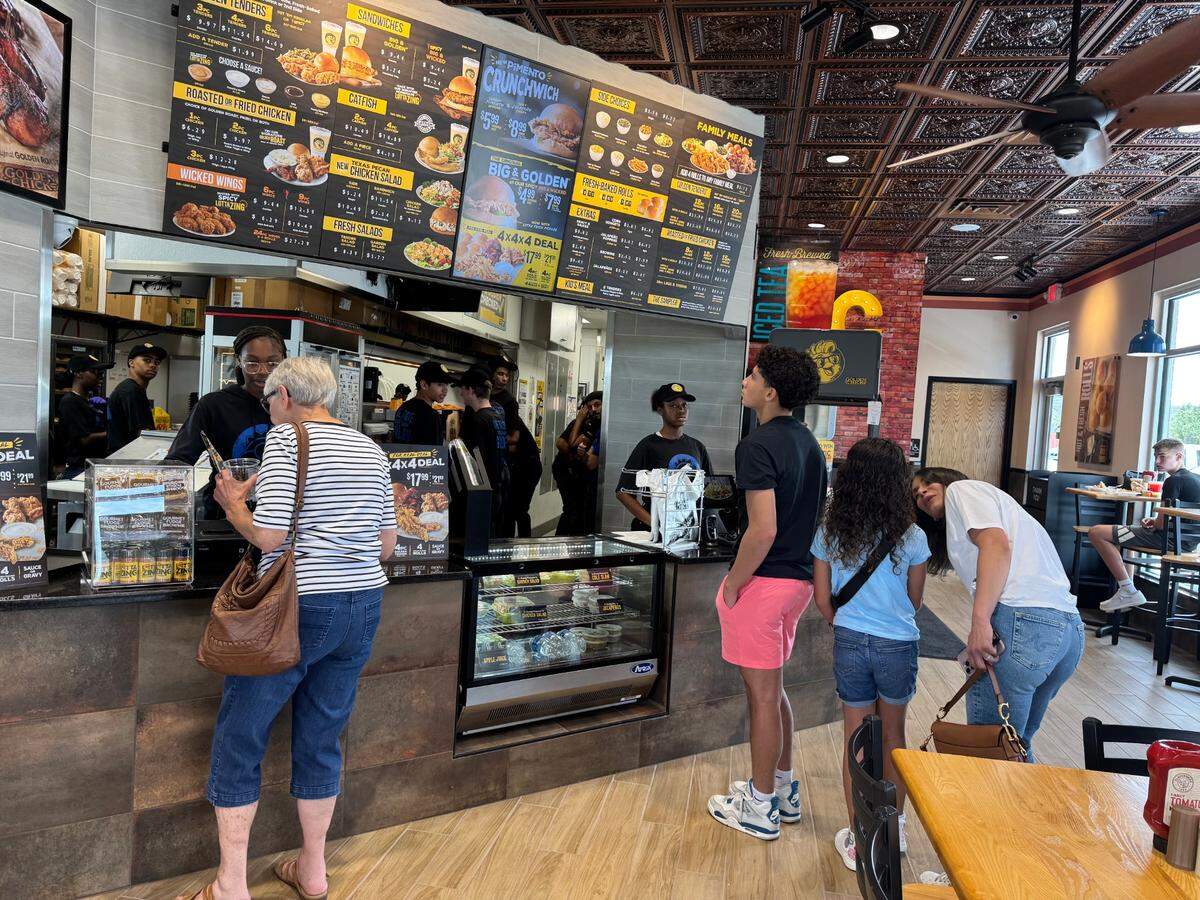 Customers line up on Monday for an invite-only soft opening at the new Golden Chick restaurant, 1705 S. Webb.