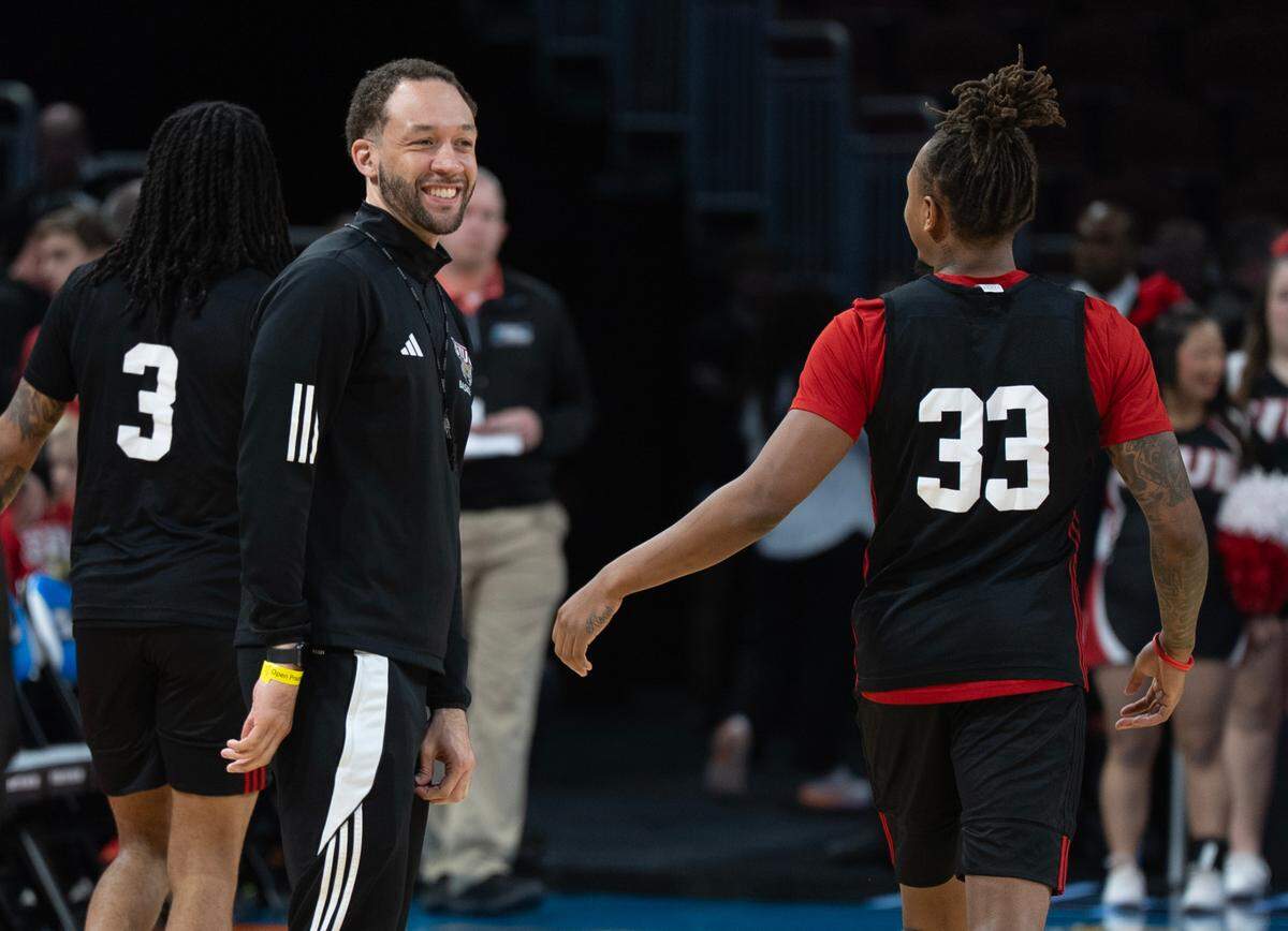 SIU Edwardsville assistant coach Jay Bradley smiles at player Jo Valrie during the open practice at the 2025 NCAA Division I Men’s Basketball Championship at INTRUST Bank Arena.