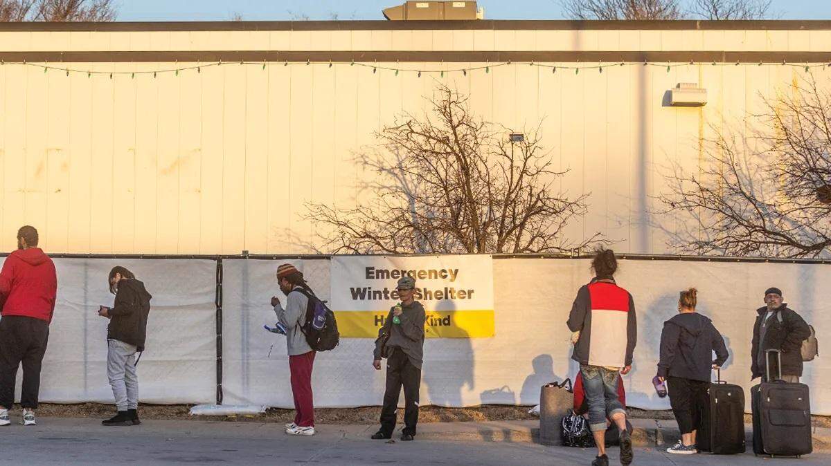 People wait in line for Wichita’s emergency winter shelter on East 21st Street last year. This year’s shelter will have the same operator but a different location, the former Park Elementary building, and some adjustments to its operations.