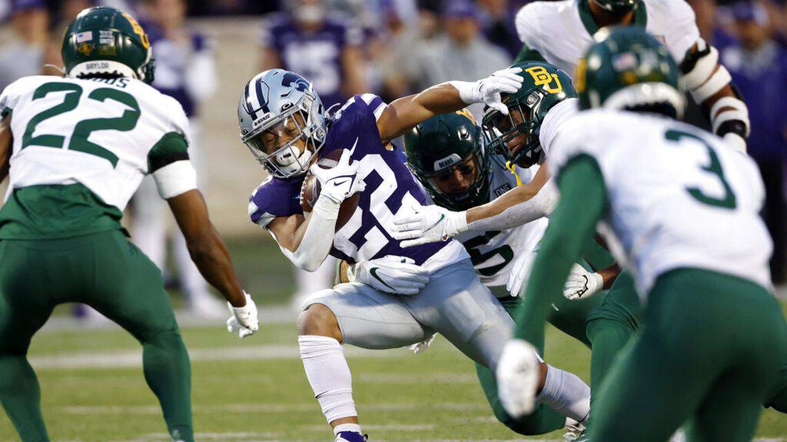 Kansas State running back Deuce Vaughn (22) rushes for a first down as he is stopped by Baylor linebacker Dillon Doyle (5) during the first half of an NCAA college football game on Saturday, Nov. 20, 2021 in Manhattan, Kan. (AP Photo/Colin E. Braley)