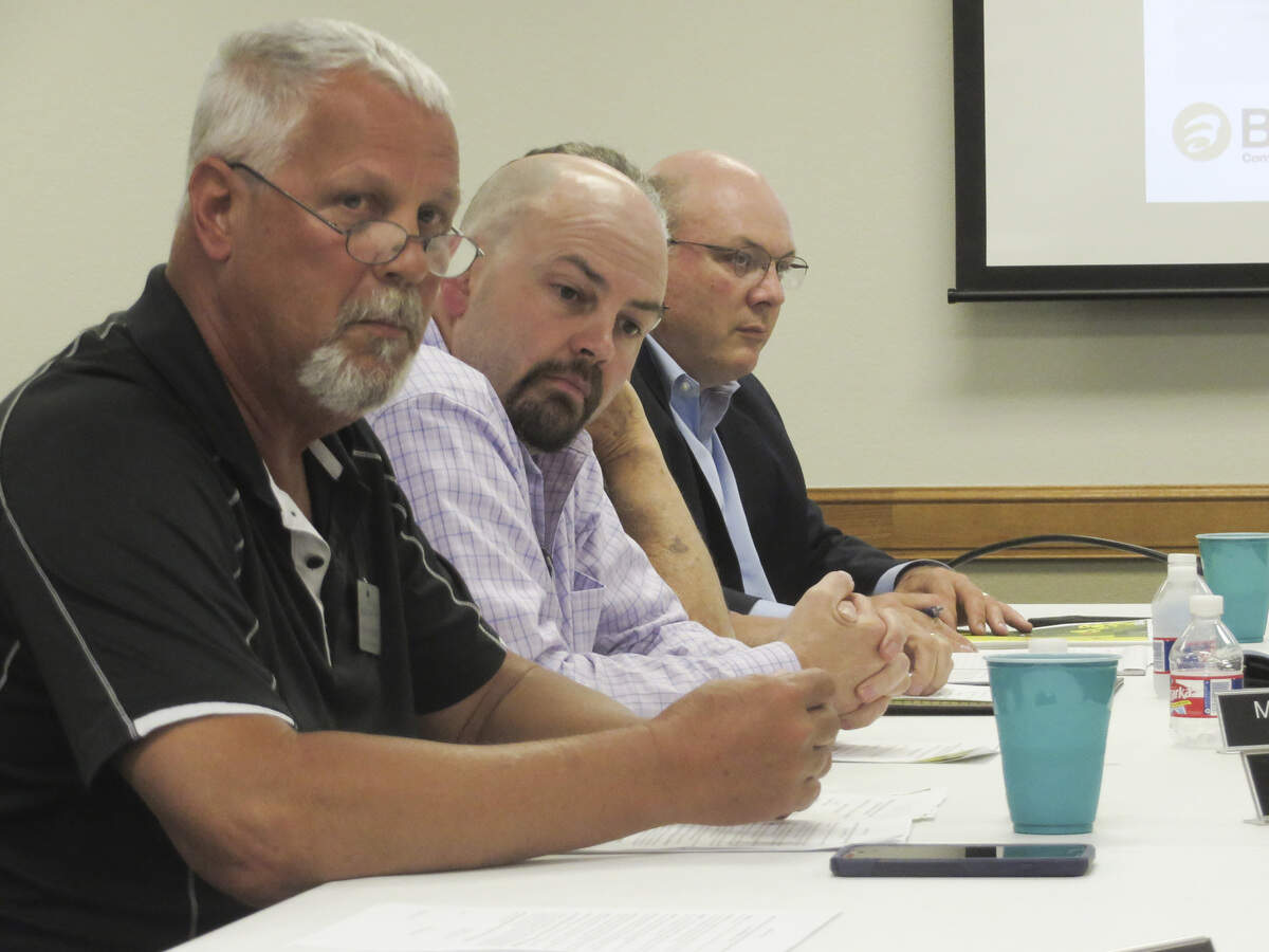 Butler County commissioners Dan Woydziak and Marc Murphy, and County Manager Will Johnson, listen to a presentation from Butler Community College during a town meeting.