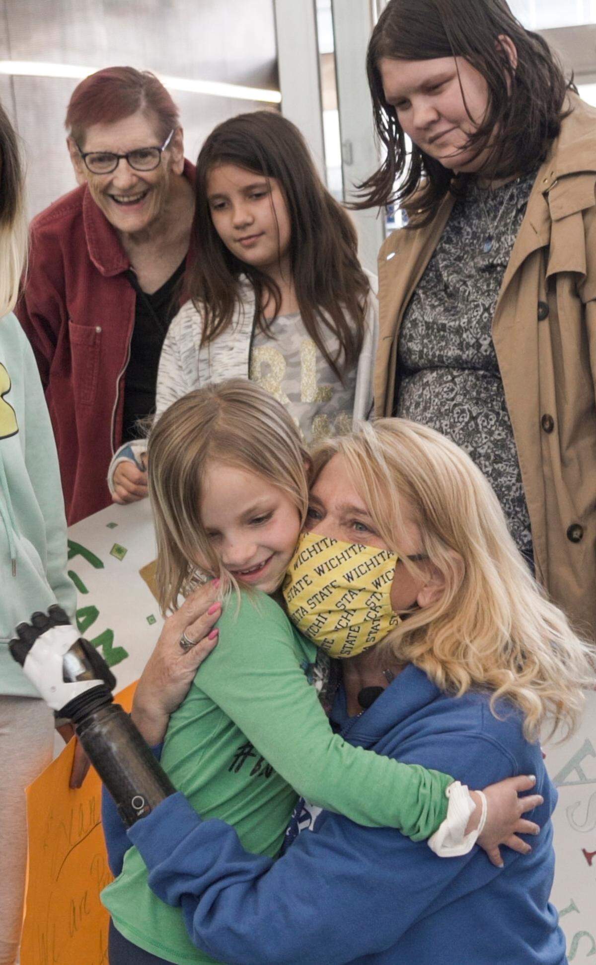 Wichita amputee Sondra Stieber hugs her 7-year-old granddaughter, Skyelar Bryant, on Wednesday after returning from New York where she was fitted for a bionic arm, which she controls with her mind.