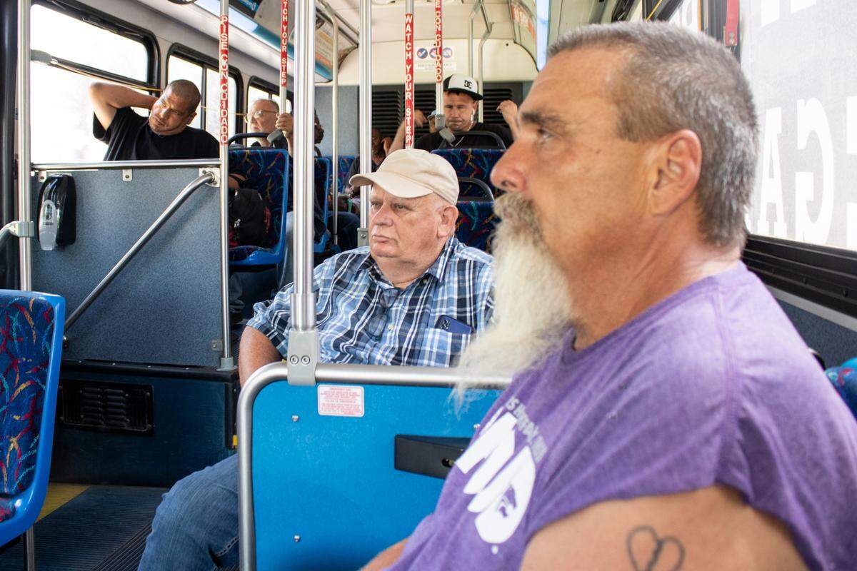 Delbert Pfeiffer (right) rides on a Wichita bus on July 11. Pfeiffer says that after years of construction work, injuries prevent him from driving his motorcycle.