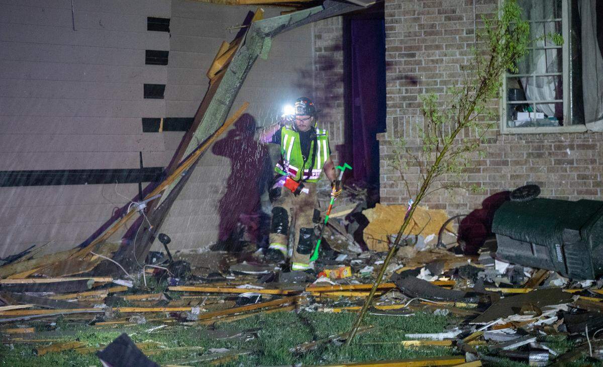 Firefighters search a home on south Hedgewood Street in Andover on Friday night after a tornado ripped through the area.