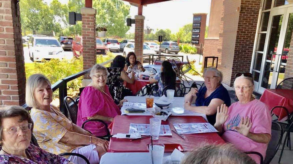 Diane Kilts, back left wearing pink, enjoys a celebratory lunch at Red Robin with members of her quilting group days after the restaurant’s staff dug through five bags of trash to find her missing wedding ring.