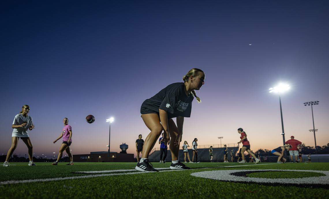 Maddison Ross hikes the ball to a teammate during flag football practice at Maize High on Wednesday morning.