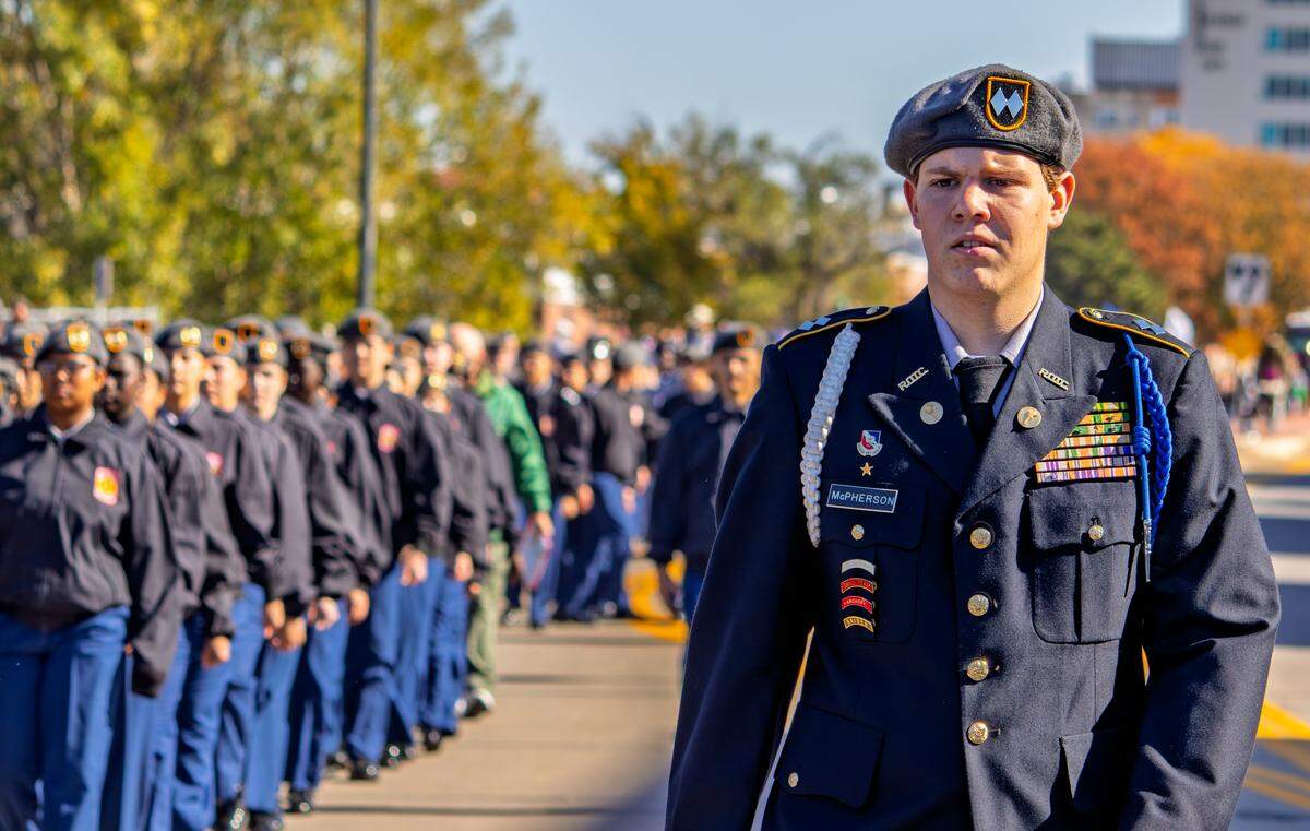 Wichita South High School Army JROTC Cadet Clayton McPherson leads other JROTC members in a march down First Street. JROTC groups from several Wichita-area schools participated in Saturday's Veterans Day parade.