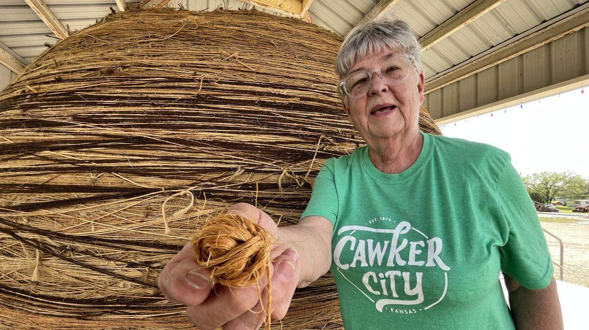 Caretaker Linda Clover, seen here in this 2022 photo, has helped countless travelers add their own piece of twine to the World’s Largest Ball of Twine in Cawker City over the past two decades.